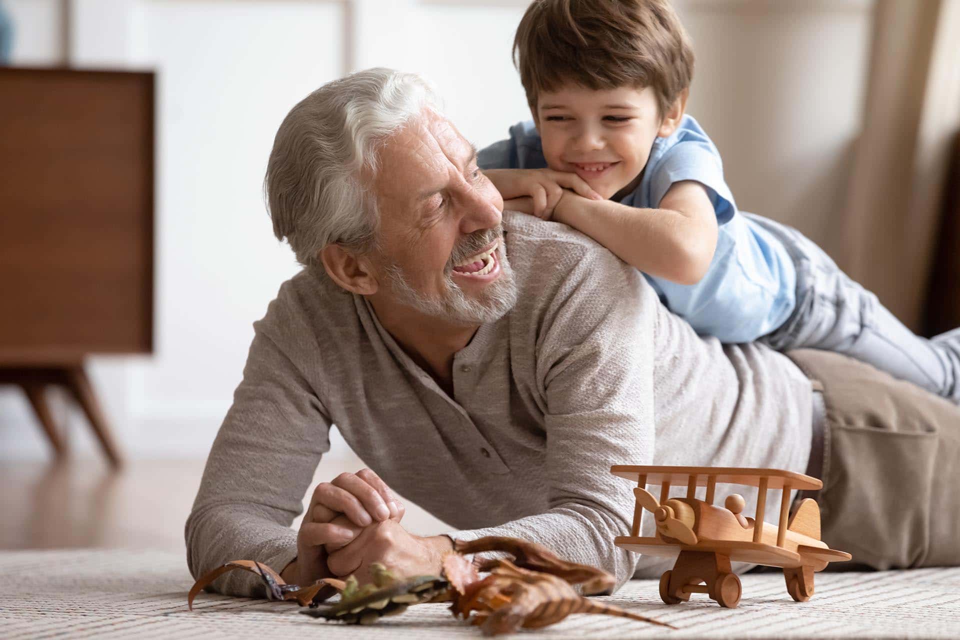 Senior man with dental implants playing with grandson