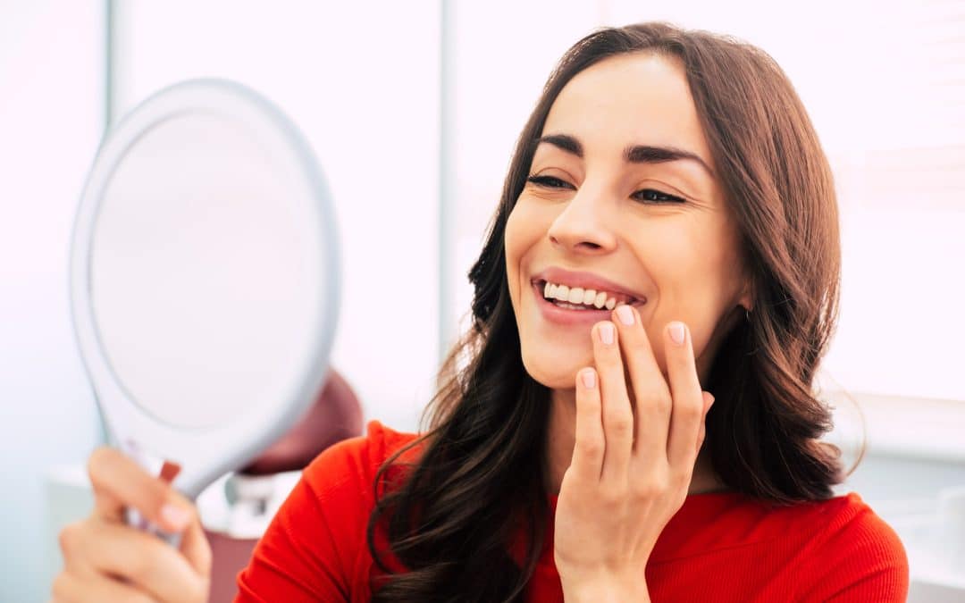 Woman looking at her new dental implants from Dr. Seale in Rincon GA